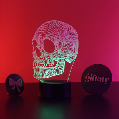 Skull-shaped LED lamp with a red and pink gradient on a dark surface, branded 'giflaty'.